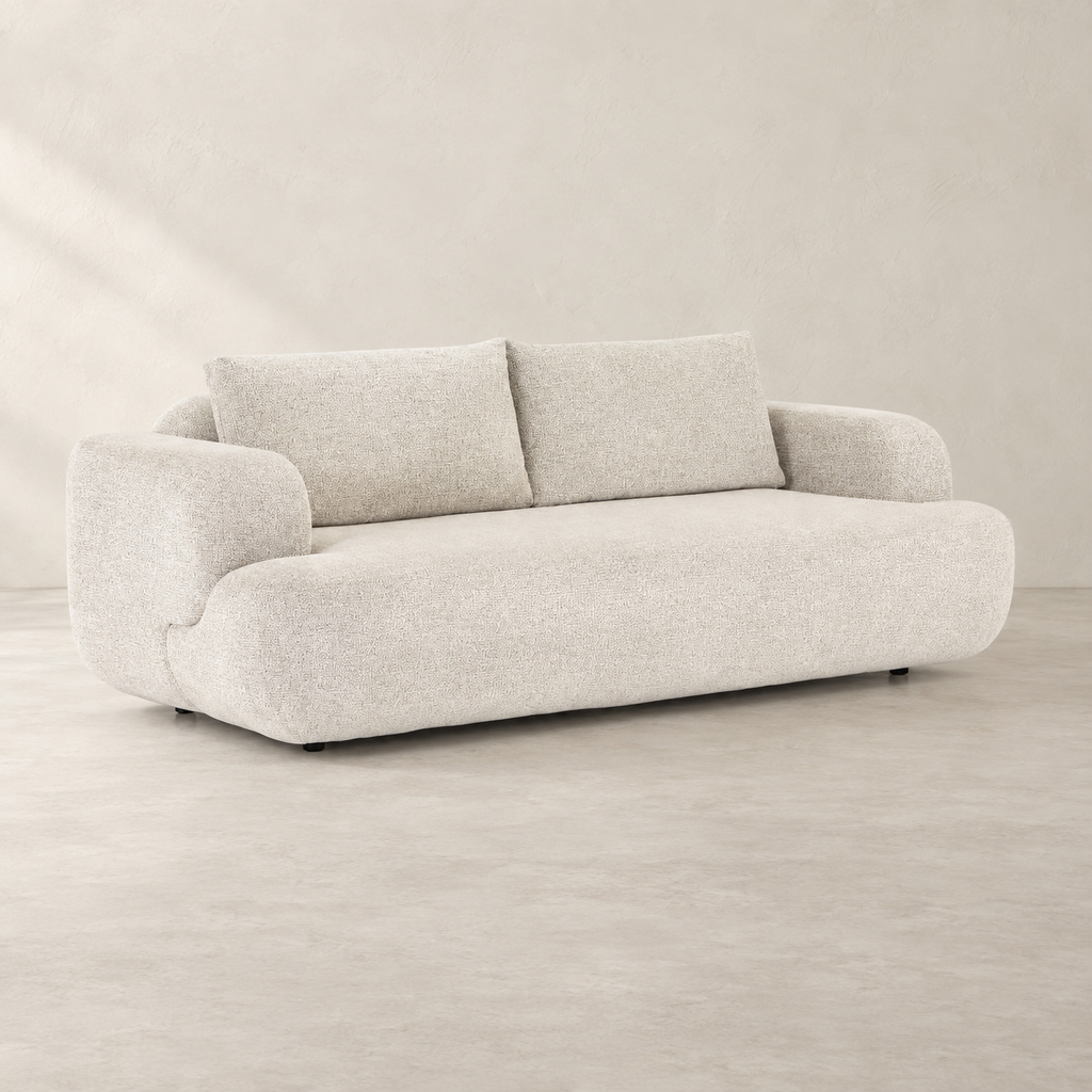 AI-assisted styled view of the Herman sofa, showing two broad back cushions, pale upholstery, rounded arms and low dark supports.