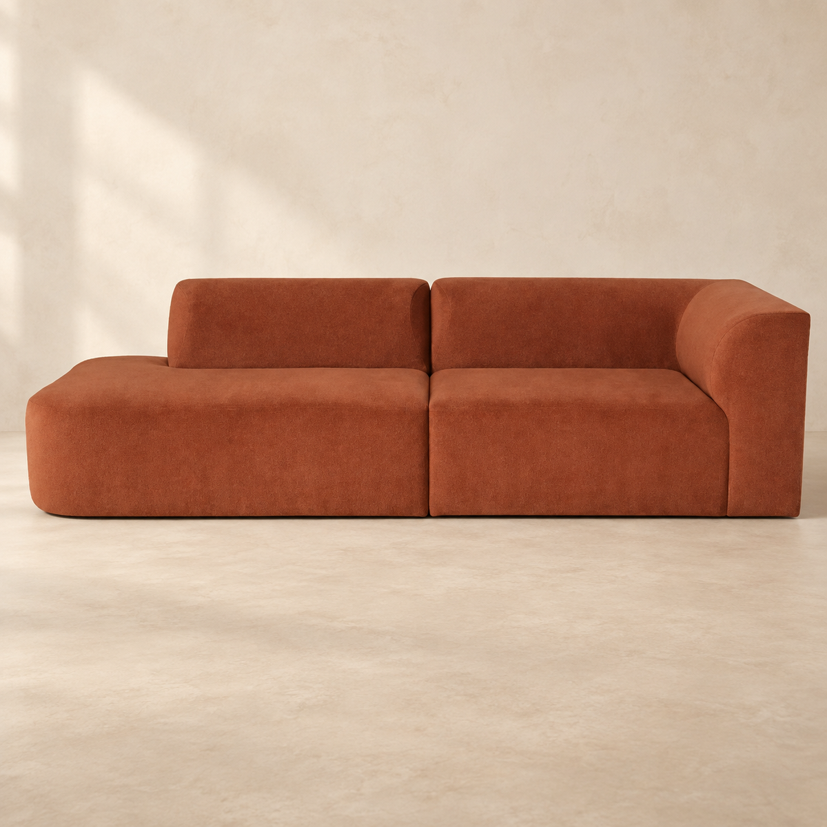 AI-assisted styled view of the terracotta Kelly sofa, showing its open left end and single right arm.