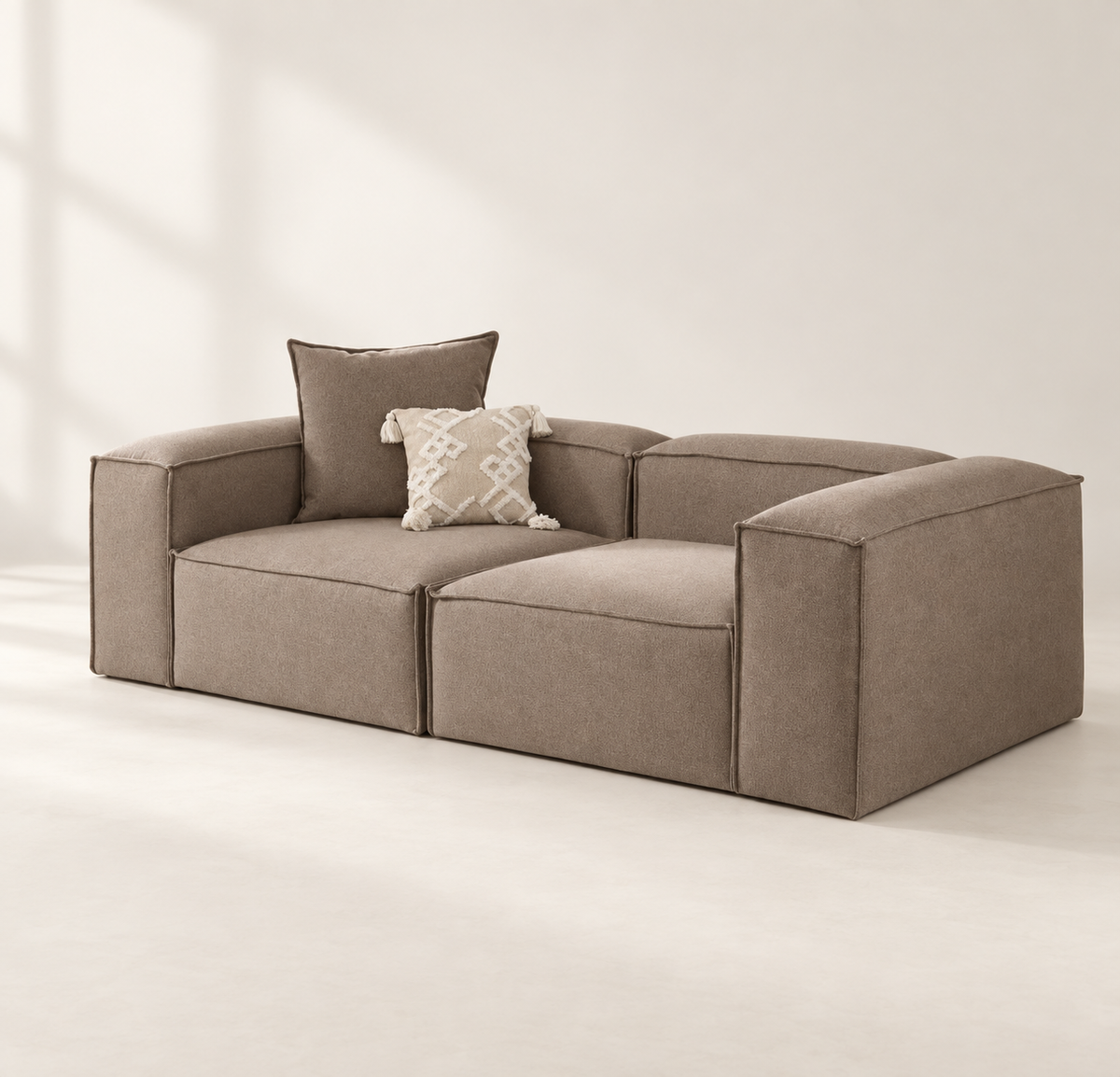 AI-assisted styled view of the taupe Leonardo two-piece sofa with broad squared arms and two loose cushions.