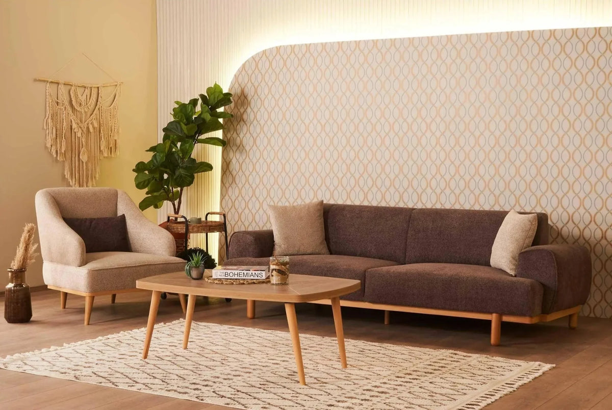 Brown sofa and cream armchair with a wooden coffee table in a softly lit living room.